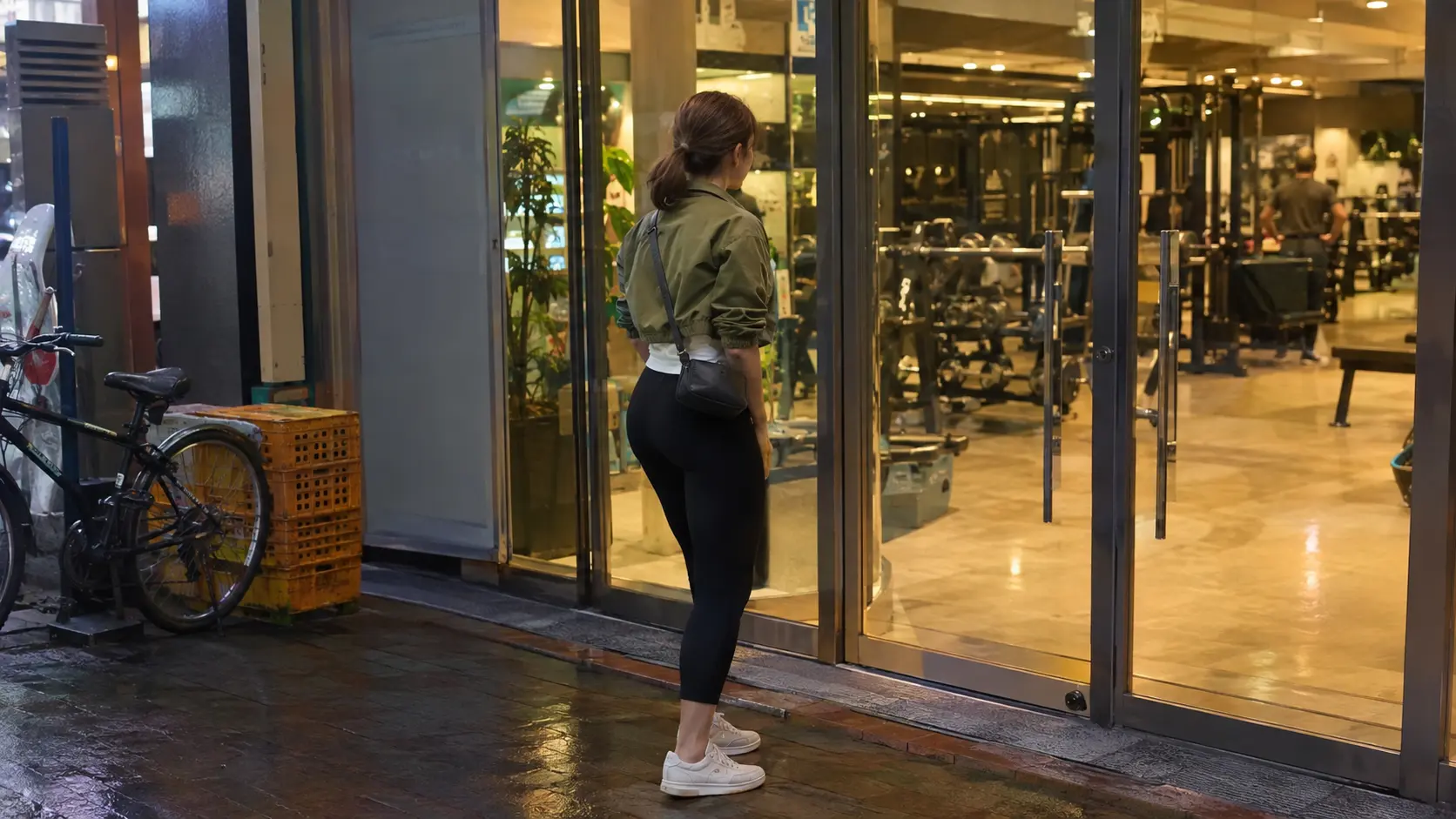 Foreign woman standing outside a Korean fitness center at dusk before signing a korean gym membership contract