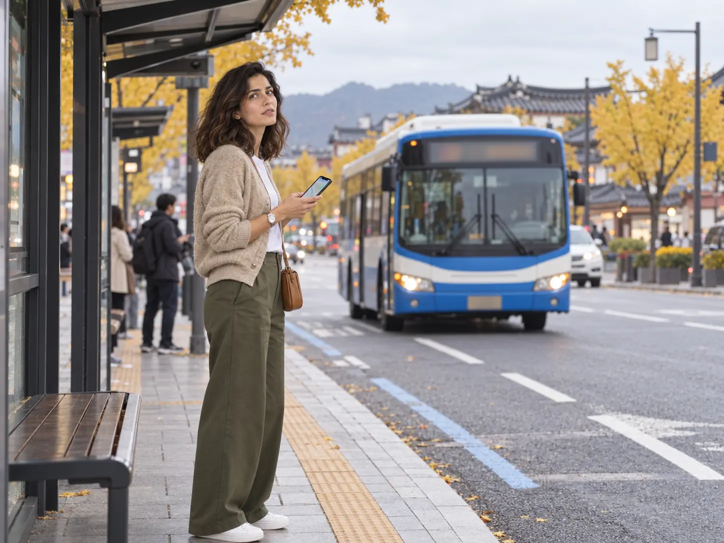 Traveler checking a bus arrival app at a Gyeongju bus stop near the intercity terminal